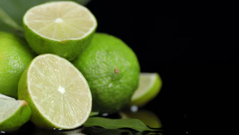 limas cortadas a la mitad y enteras con las hojas girando lentamente.