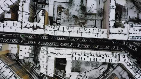 aerial view over snowy buildings and streets in warsaw, poland - overhead, drone shot