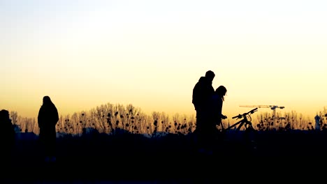 silhoette of people in fron of sunset sky