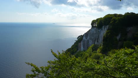 chalk cliffs ruegen germany with baltic sea in background partly cloudy on a summer day with green forest