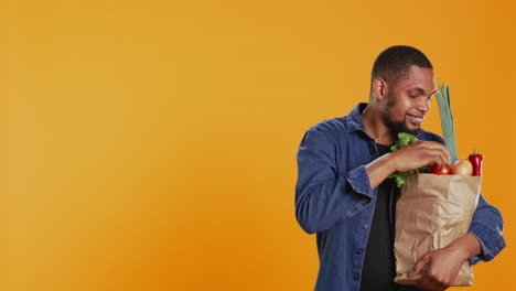 hombre vegano admirando frutas y verduras recién cosechadas