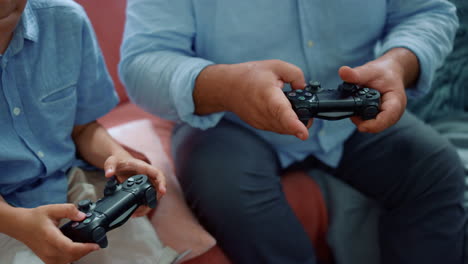 hombre y niño manos jugando un juego de computadora. abuelo y nieto usando joysticks