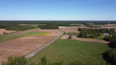 carreteras rurales vientos a través de campos agrícolas, verde bosque del norte