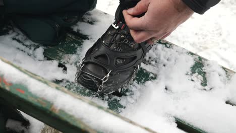 a hiker putting crampon on his winter boots