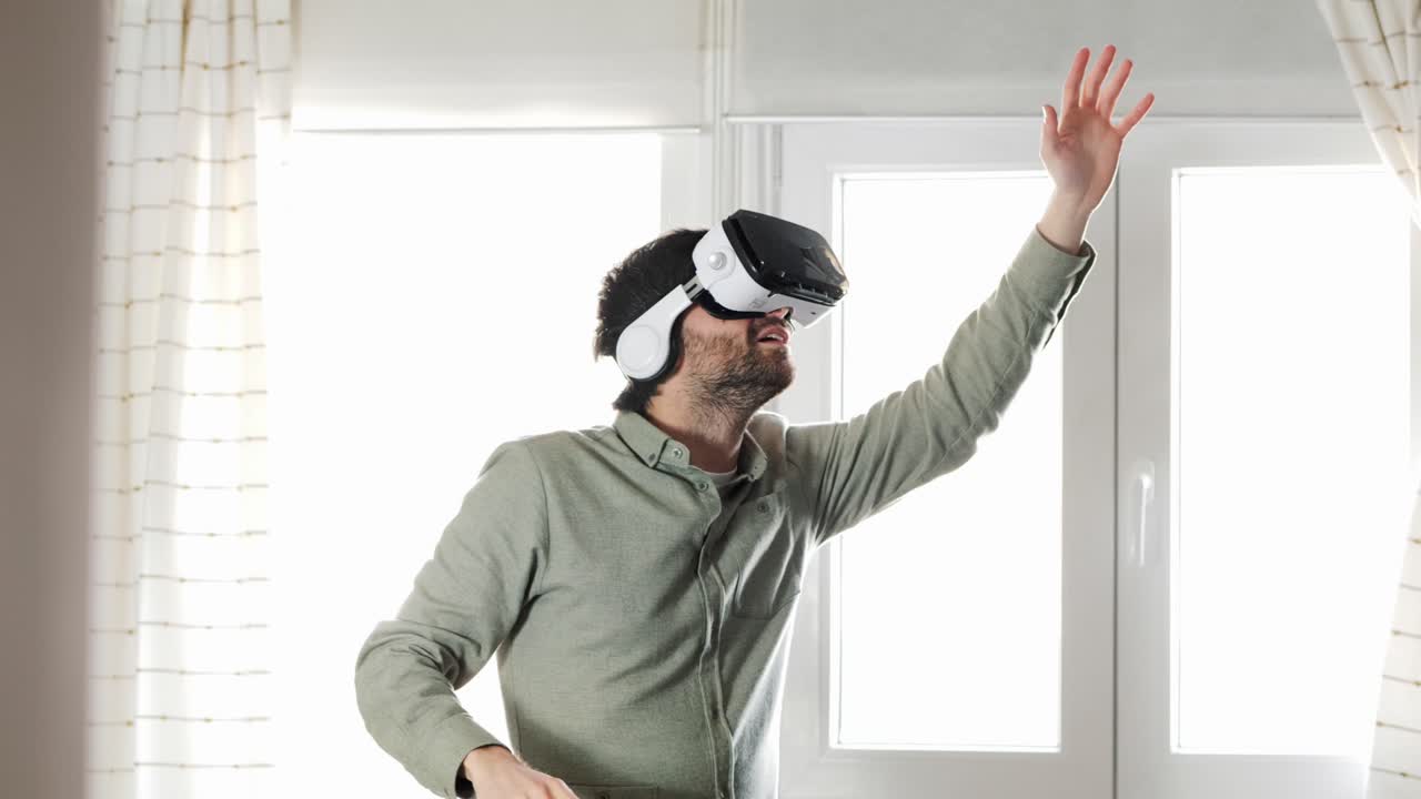 Giovane uomo che esplora il cyberspazio con un visore VR a casa