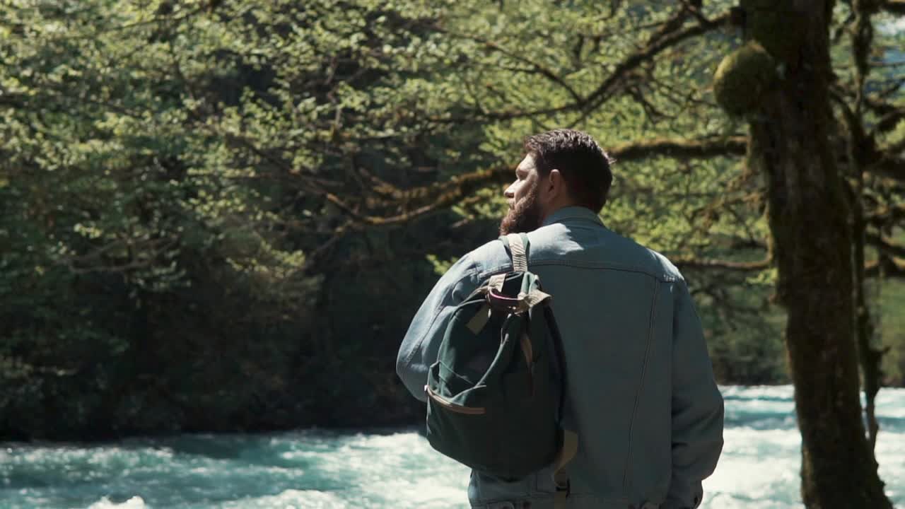 hombre caminando por un río en un bosque