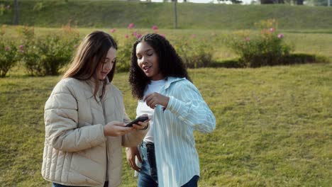 teenage friends taking selfies in a park