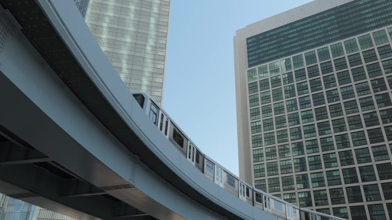 mirando hacia arriba en ángulo amplio del monorraíl de tokio yurikamome pasando en un día soleado con rascacielos en el fondo