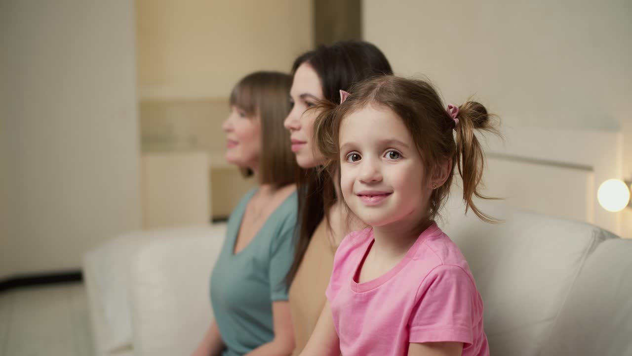 세 세대의 여성. 아름다운 할머니, 어머니와 딸은 카메라를 보고 차례로 미소 짓고 있습니다