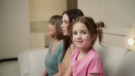 tres generaciones de mujeres. hermosa abuela, madre e hija están mirando a la cámara y sonriendo a su vez