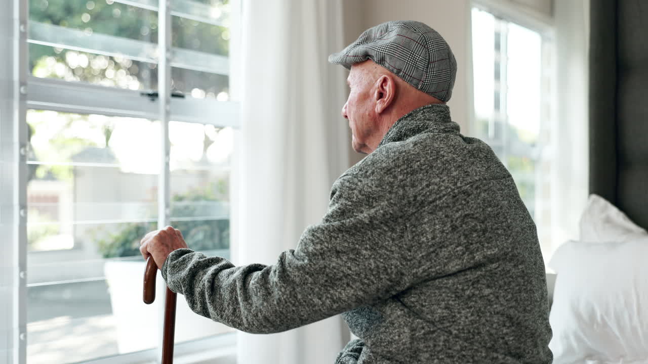 Elderly man looking out the window
