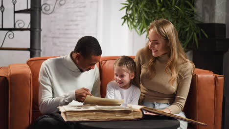 black father shows old photo to daughter and blonde wife