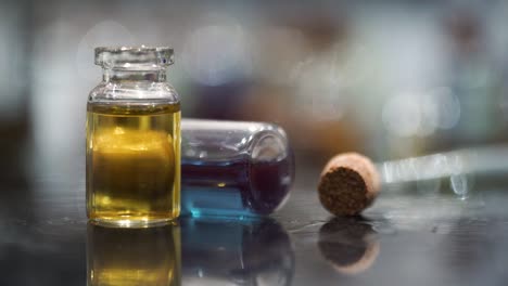 small two glass bottles yellow blue liquid macro close up no action
