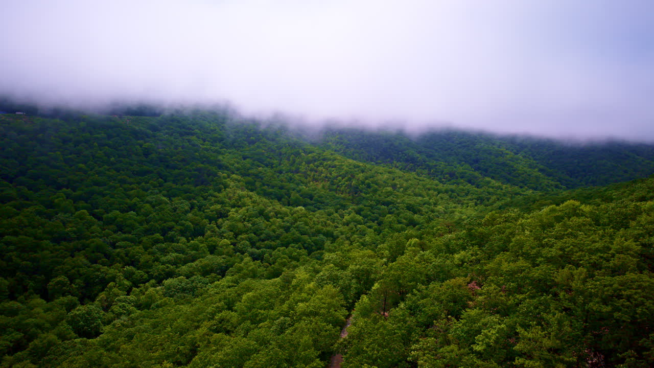Cinematic flyover with mountains disappearing into fog