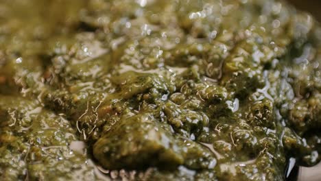 cooking green pesto sauce close-up. italian pesto is a sauce that traditionally consists of crushed garlic, european pine nuts, coarse salt, basil leaves, and hard cheese such as parmigiano-reggiano, parmesan or pecorino sardo all blended with olive oil. high quality 4k footage