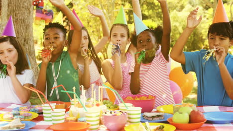 group of children blowing party horns at tech picnic, with animated sales graph floating over cake