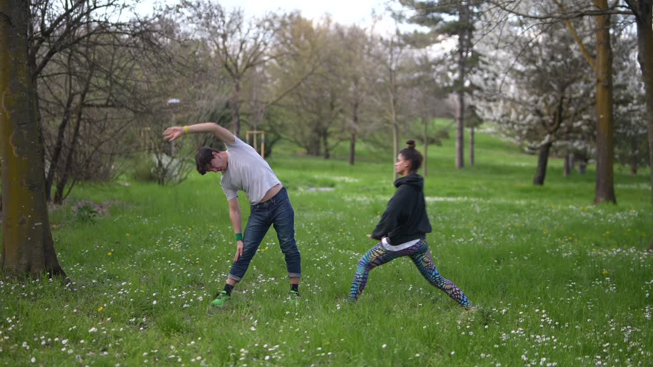 una pareja estirándose en el parque.