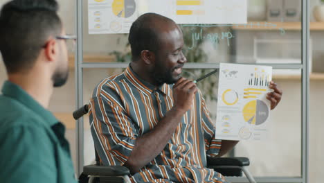 Black Man with Disability Presenting Business Plan to Colleagues