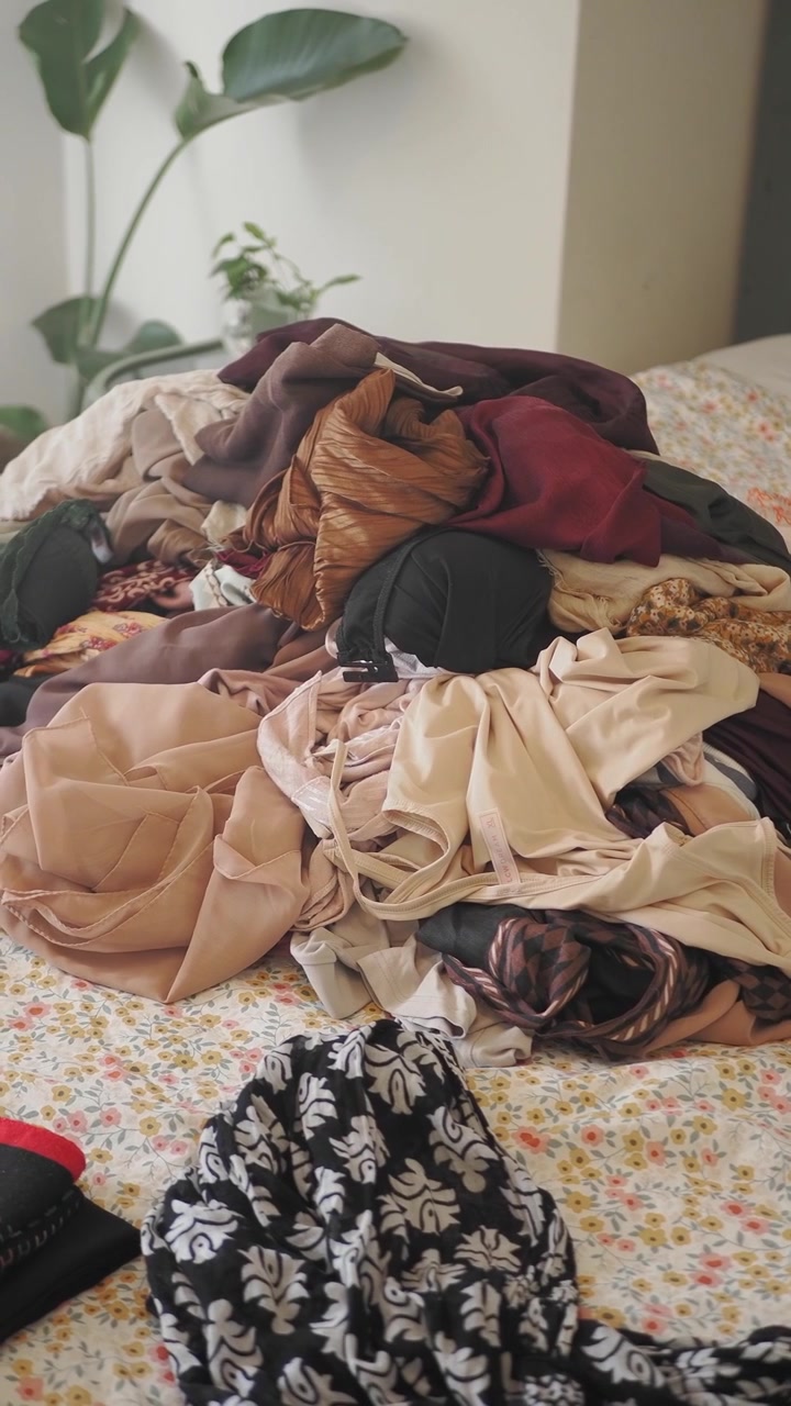 Large Pile of Messy Clothes on a Bed in a Bedroom