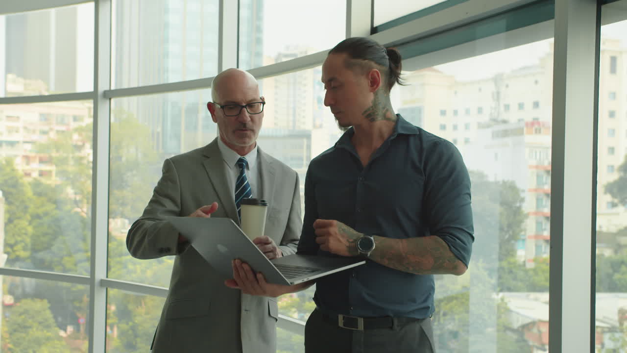 Male Manager Showing CEO Plan of Project on Laptop in Office