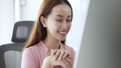 a young woman experiences a moment of joy while working at her desk in a bright digital workspace.