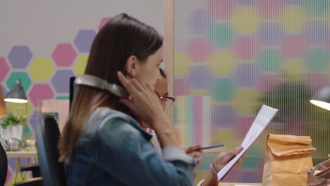 business people working caucasian team leader woman sharing advice pointing at screen discussing project showing support using computer in colorful office