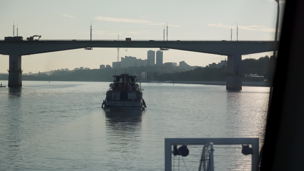 Boat on River Under Bridge with Cityscape
