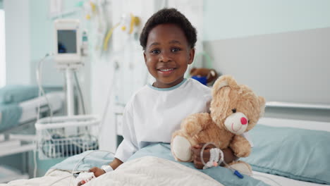 african boy kid, hospital and teddy bear on bed