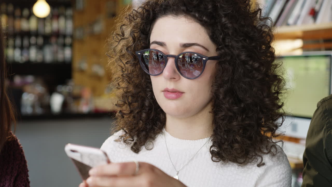 mujer con cabello rizado usando un teléfono inteligente
