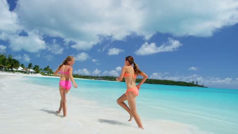 caucasian sisters in swimwear on luxury island beach