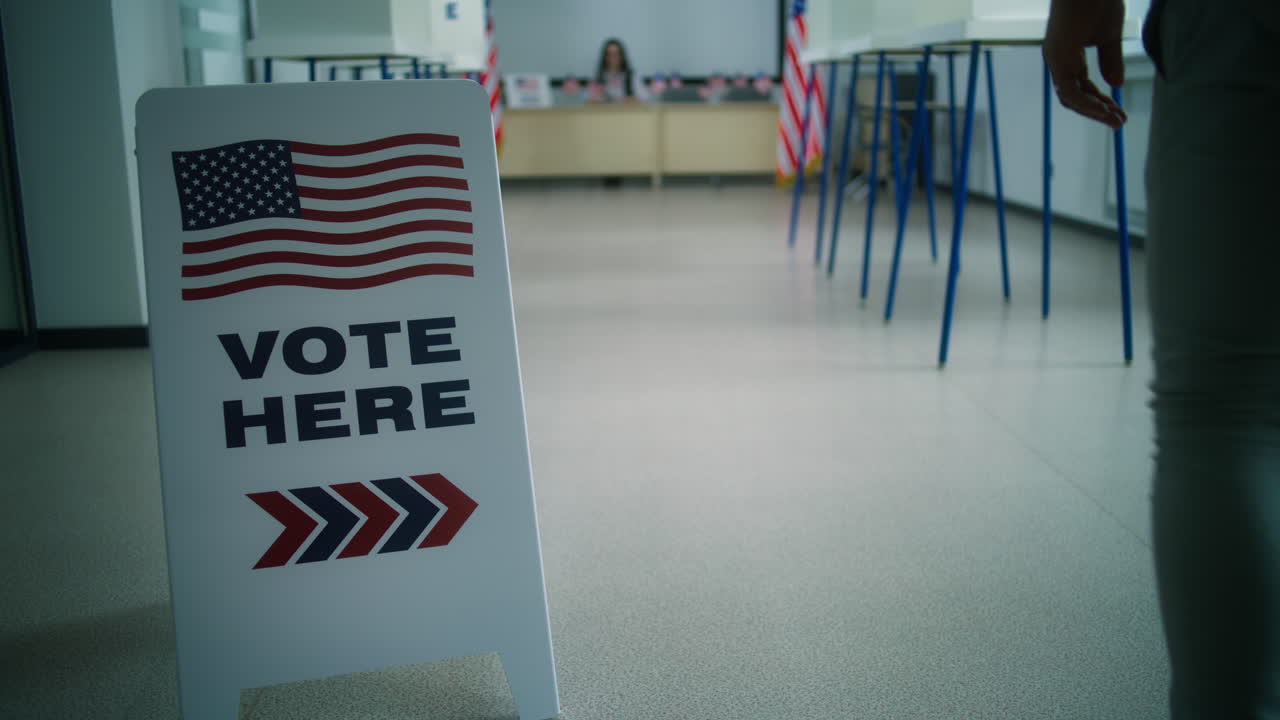 African American Man Walks to Female Polling Officer for Registration African American Man Male Voter Walks to Female Polling Officer for Registration at Polling Station Takes Paper Ballot for Voting National Election Day in the United States of America Civic Duty