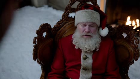 santa claus resting by the fireplace