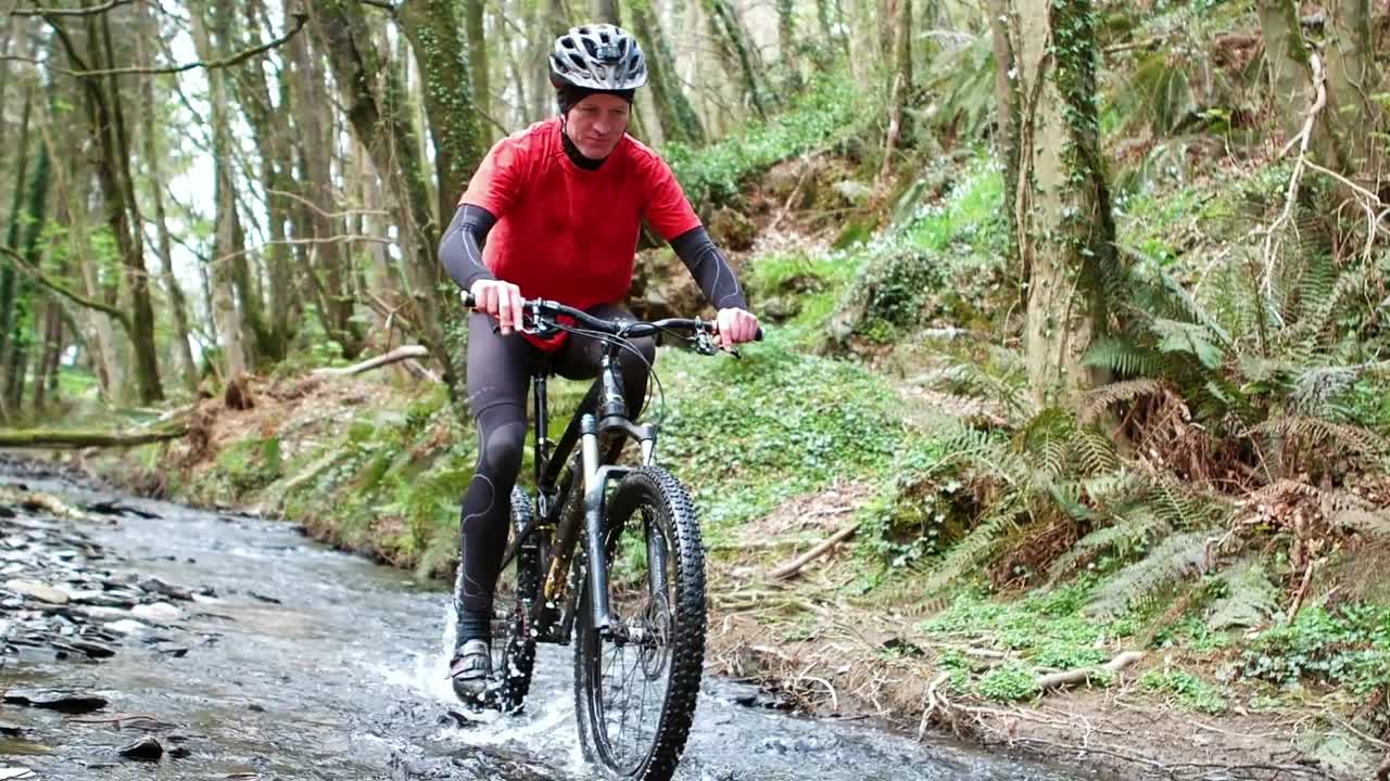 Mountain biker riding bicycle in creek