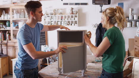 couple in workshop upcycling and working on cabinet together