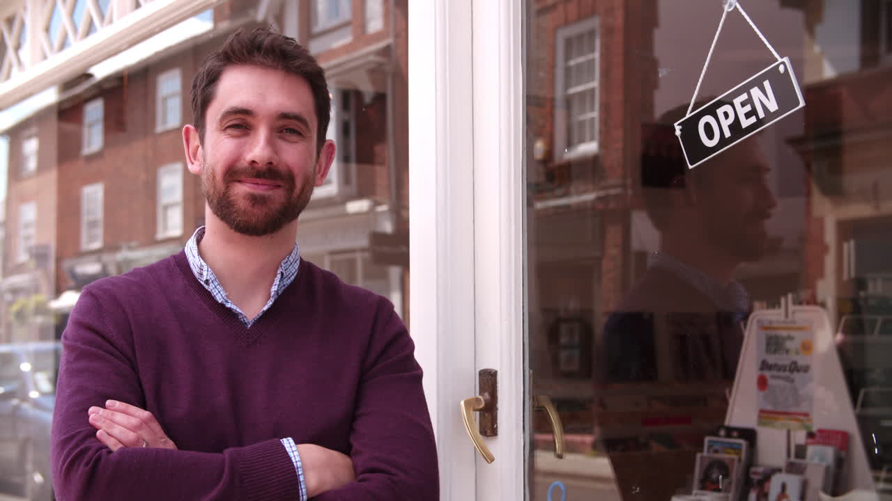 el dueño de la tienda de pie fuera de su tienda