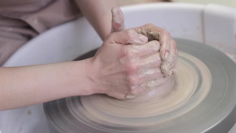 video women's hands make a plate of clay on a potter's wheel.