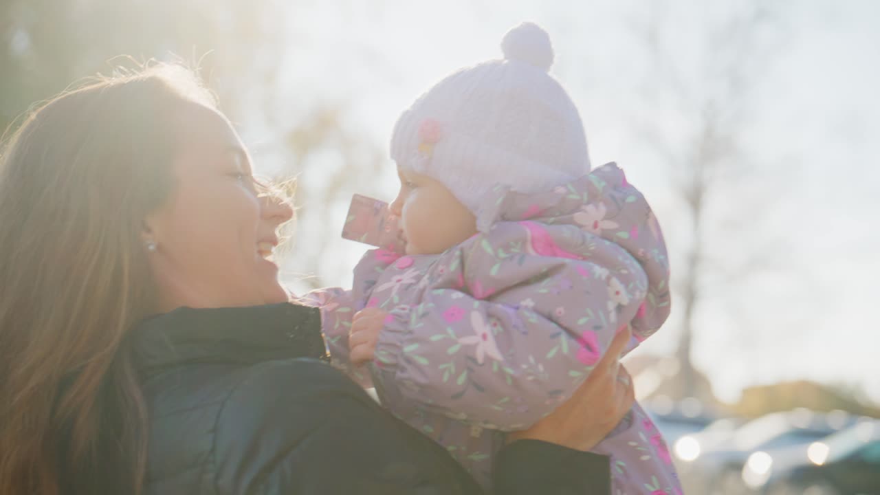 Um momento emocionante: uma mãe abraçando seu bebê em uma suave luz natural, capturando a conexão alegre e o amor em seus rostos contra um plano de fundo brilhante