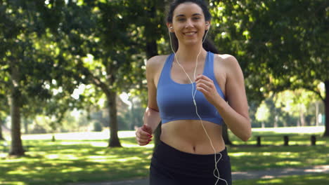 una morena feliz corriendo en el parque