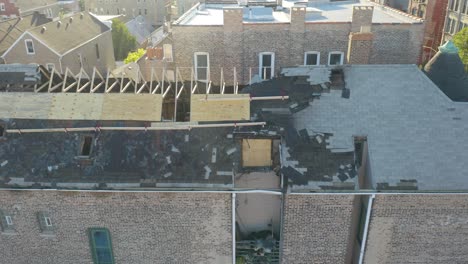 Aerial-drone-shot-from-right-to-left-of-burnt-roof-structure-of-an-abandoned-house-on-a-sunny-day