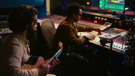 guitarist recording his electro acoustic instrument and song in studio