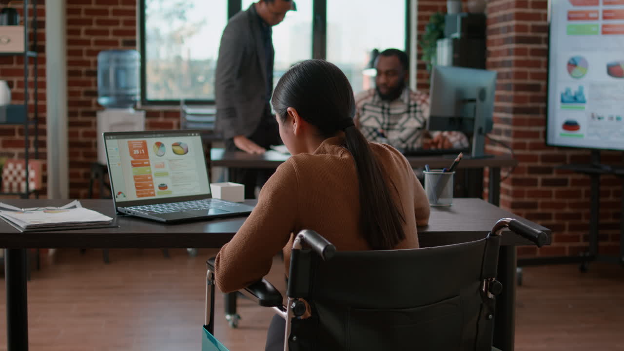 Woman with physical disability looking at charts and graphs