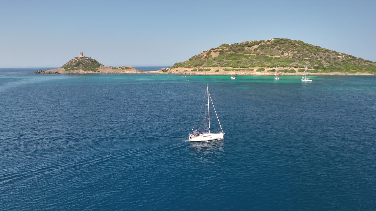 barco de vela navegando sobre el tranquilo mar azul frente a la costa de córcega