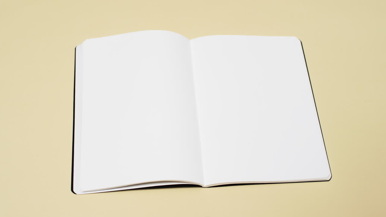 Video of book with white blank pages and copy space on yellow background