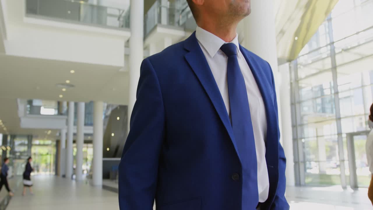 Uomo d'affari caucasico che cammina nella hall dell'ufficio 4k