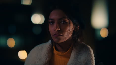 portrait-of-beautiful-young-mixed-race-woman-on-rooftop-at-night-looking-serious-with-bokeh-city-lights-in-urban-skyline-background