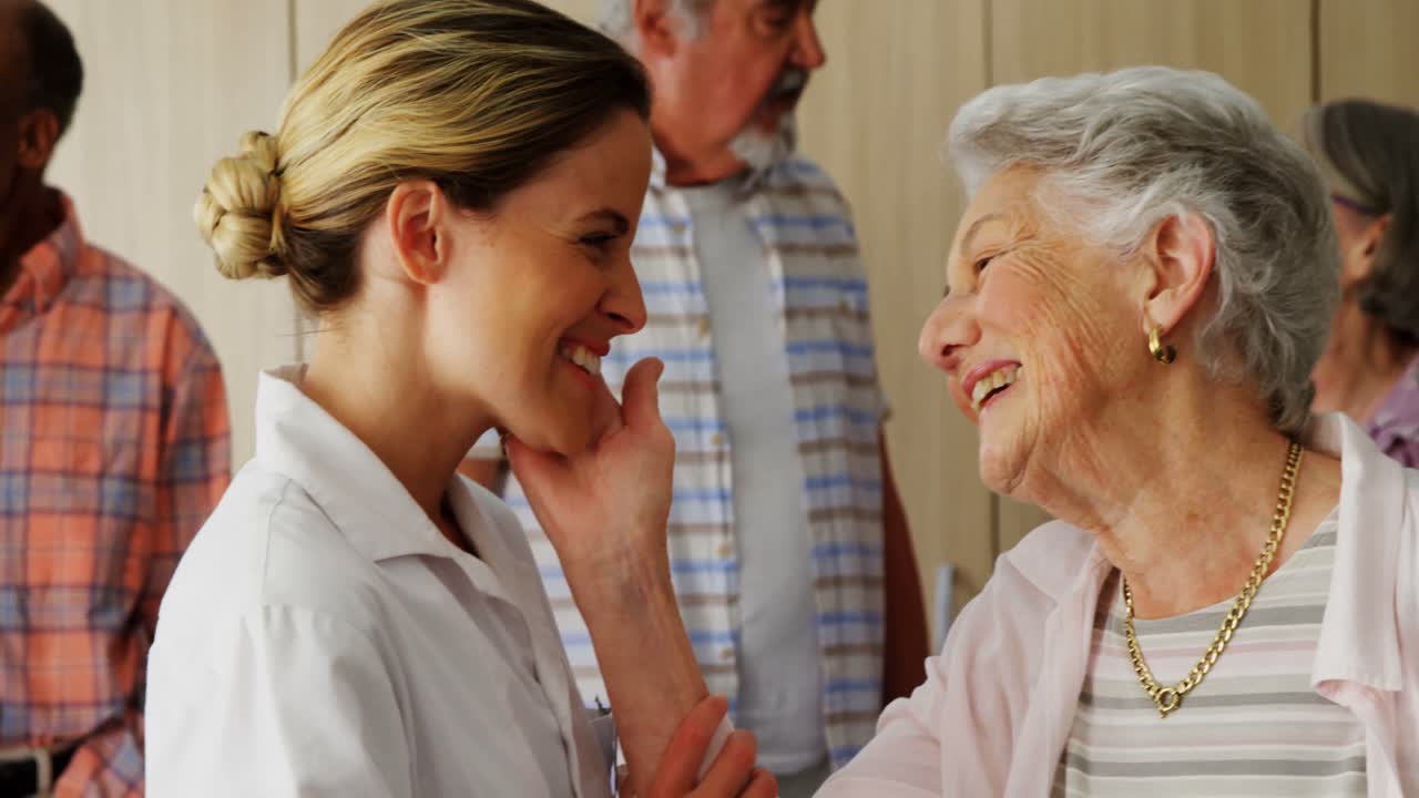 행복한 여성 의사와 고령 여성이 얼굴을 마주보고 있습니다. 4k