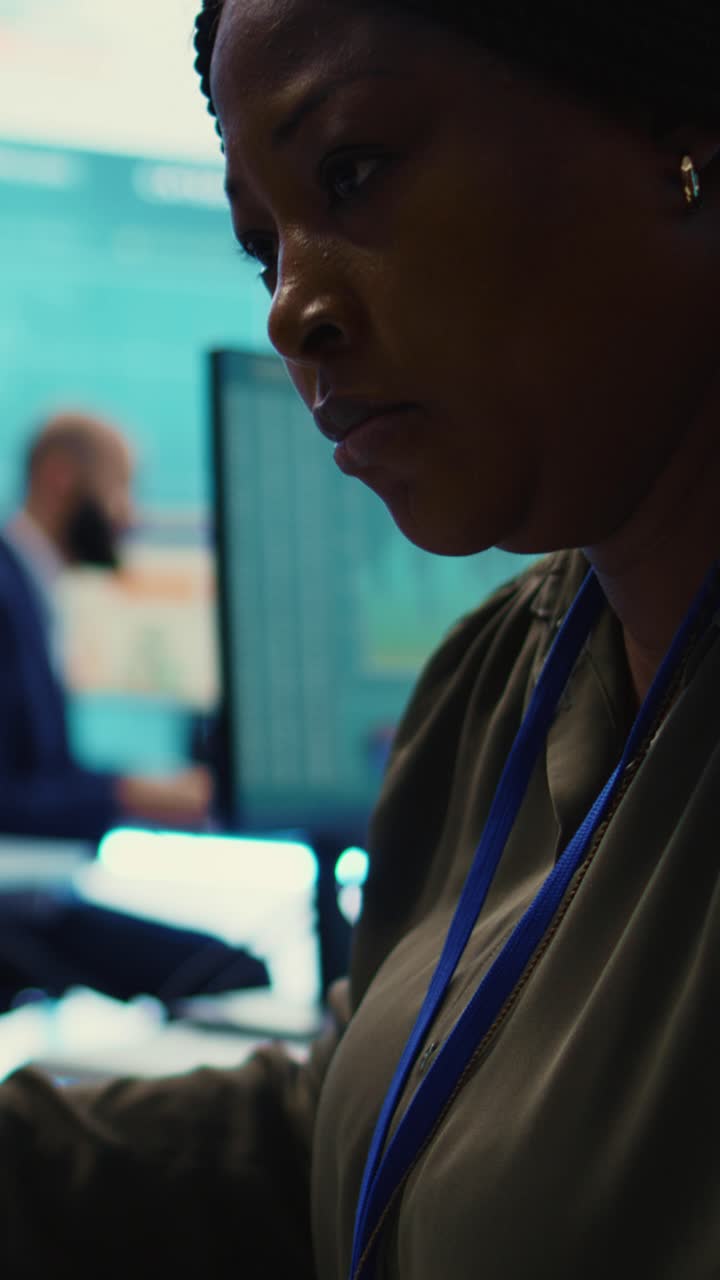 Afroamerikansk kvinde, der arbejder på computer i moderne kontor