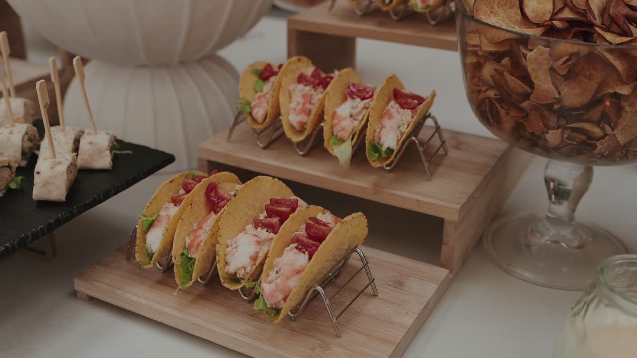 Primer plano de tacos de gambas con lechuga y tomate servidos como aperitivos para fiestas