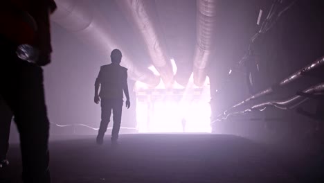 silhouette of many construction workers walking out from a large tunnel