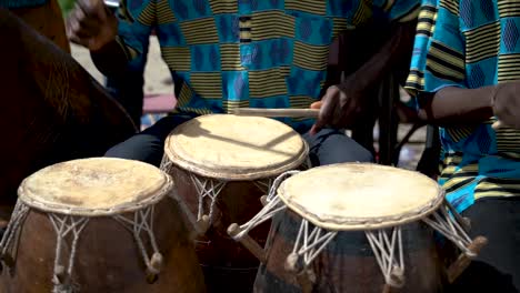 filmed in slow motion, a closeup shot shows drummers playing at a festival in rural ghana, west africa